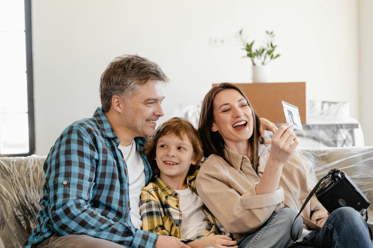 Familie im neuen Zuhause zwischen Umzugskartons – Post soll an die neue Adresse nachgesendet werden