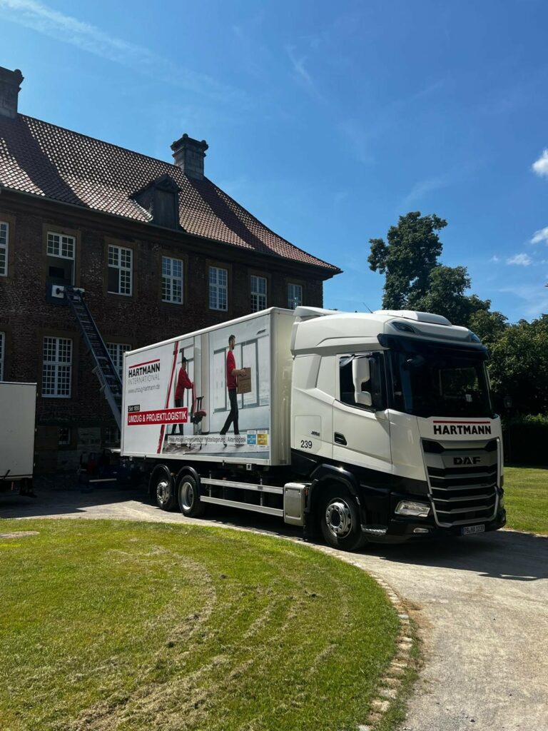 Hartmann International Umzugstransporter vor dem historischen Kloster Herzebrock.