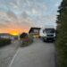 Umzugstransporter in Privateinfahrt in der Schweiz. Im Hintergrund ist ein Sonnenuntergang zu sehen.